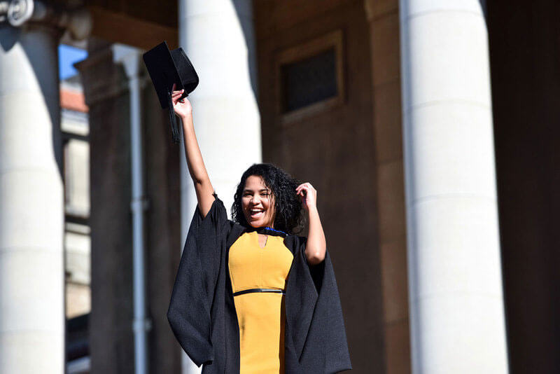 Graduating student holding up cap