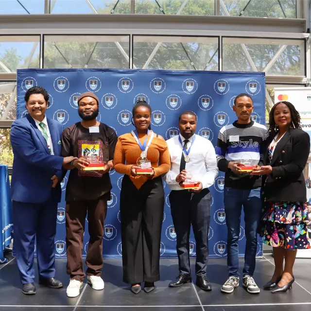 Group of six people in front of a UCT banner