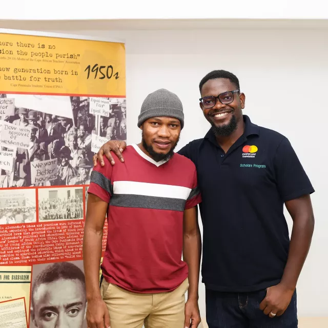 Two people in front of a banner